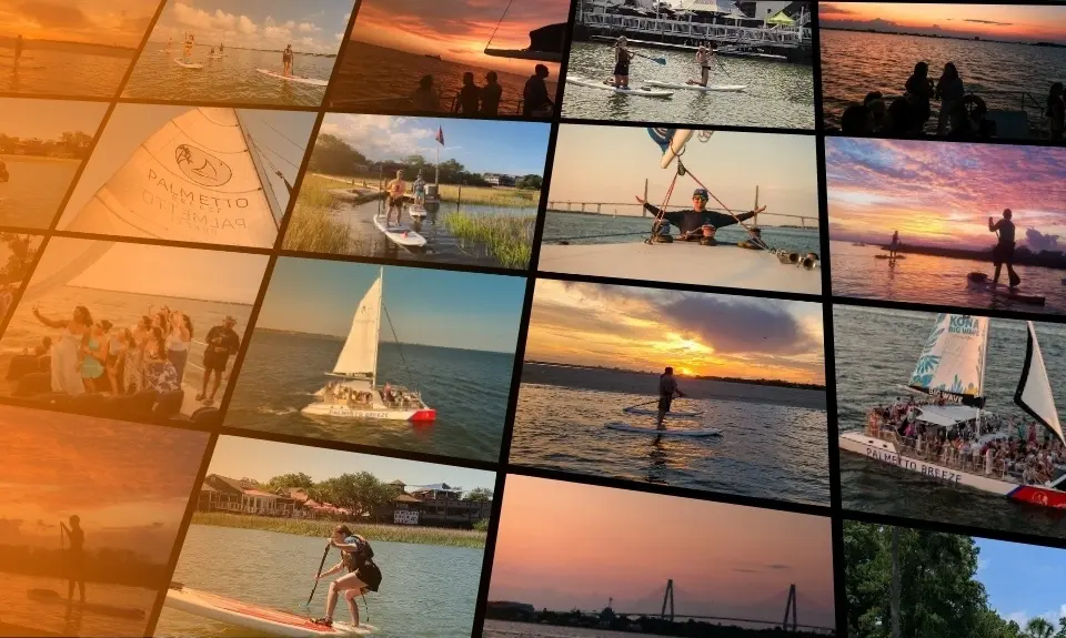 Stand up paddleboarders on Shem Creek and the Palmetto Breeze catamaran under sail at sunset in Charleston Harbor